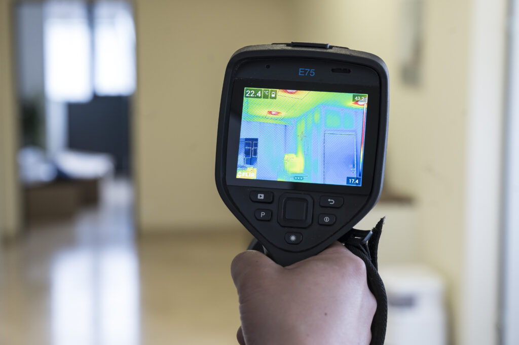 Mann mit Handgerät zur thermografischen Sichtbarmachung von Temperaturunterschieden zur Leckortung in der Steiermark.